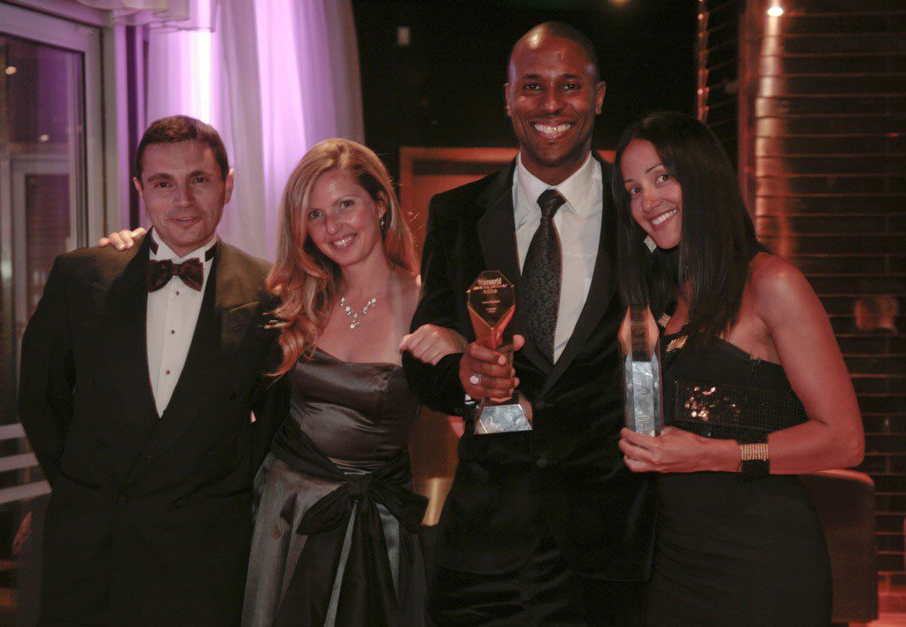 Image of Laban holding award with London Apple head office team, Richard West, Ingrid Kirschner and Georgina Dias